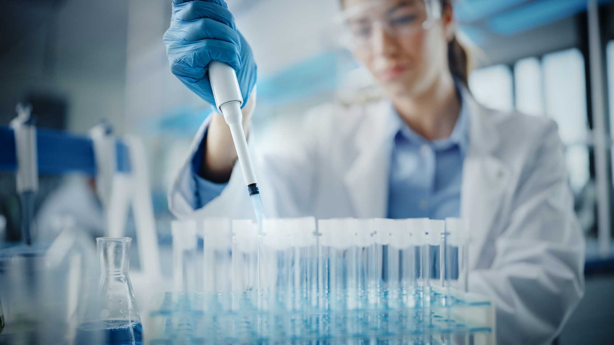 Medical Research Laboratory: Portrait of a Beautiful Female Scientist in Goggles Using Micro Pipette for Test Analysis. Advanced Scientific Lab for Medicine, Biotechnology, Microbiology Development